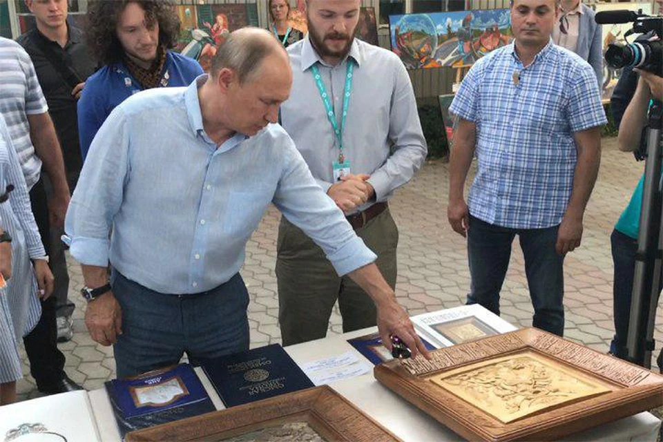 Путин осмотрел стенд, где были представлены деревянные резные иконы