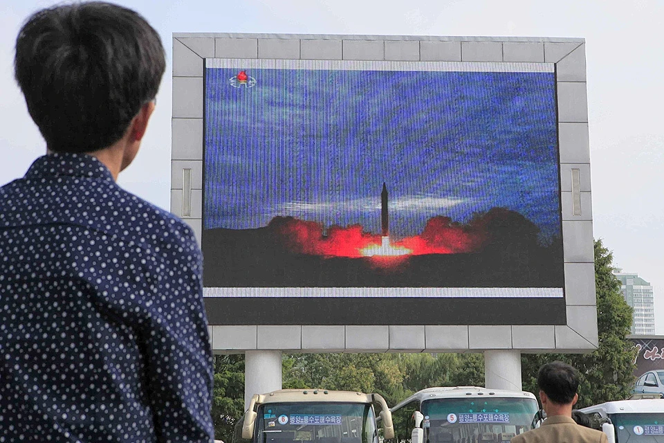 Житель Северной Кореи наблюдает за сюжетом об успешном испытательном запуске ракеты на экране в Пхеньяне.