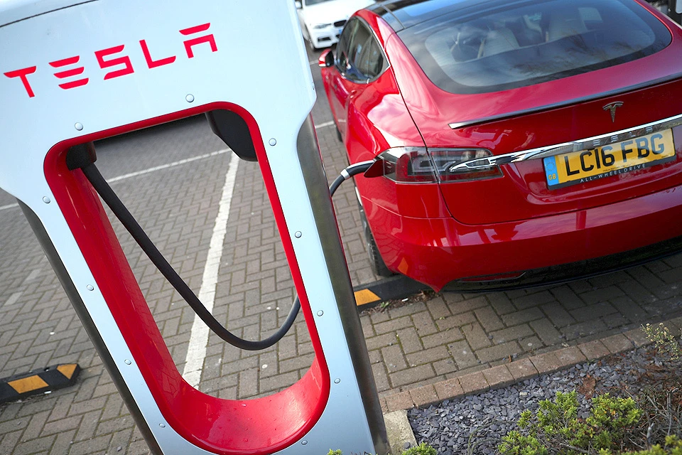 Автомобиль Тесла заряжает свои батареи на специальном пункте в Лондоне.