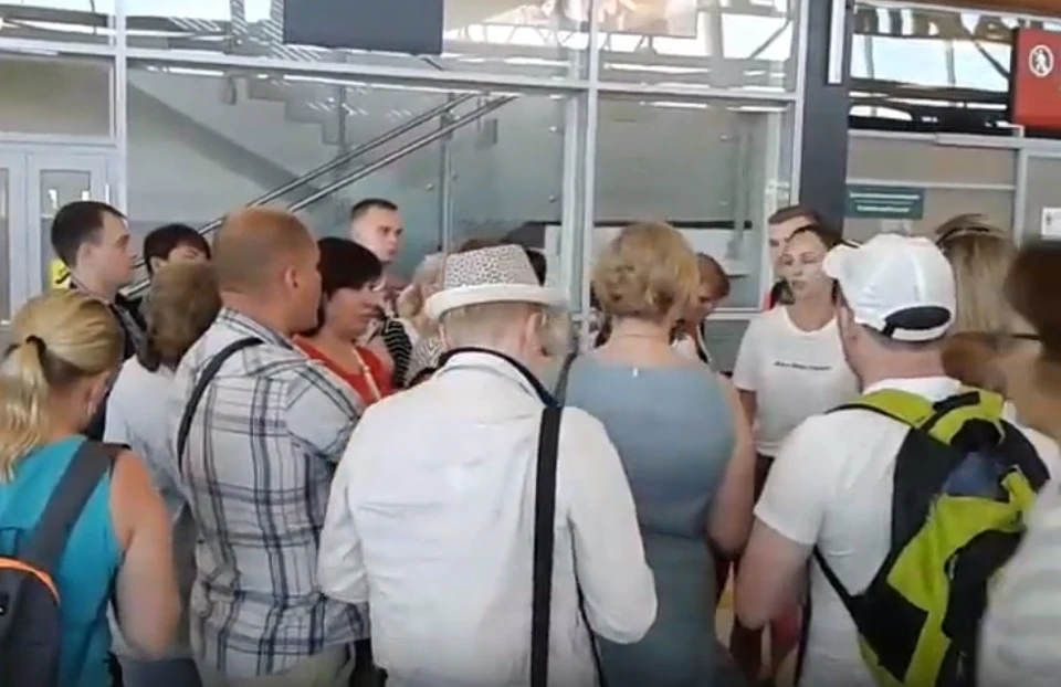Возмущенные туристы разговаривают с представителем аэропорта. Скриншот с видео туристки Татьяны Поповой