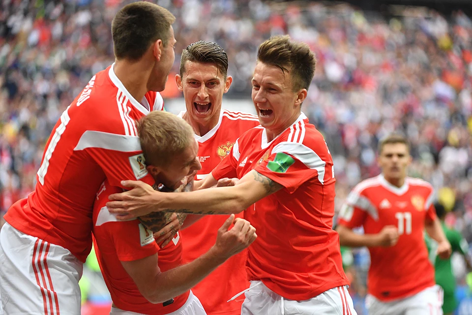 Российские футболисты празднуют гол во время первого матча домашнего чемпионата мира.