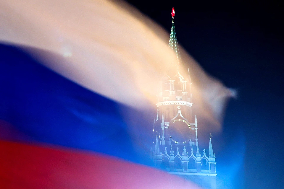 Российский флаг на фоне Спасской башни в столице.