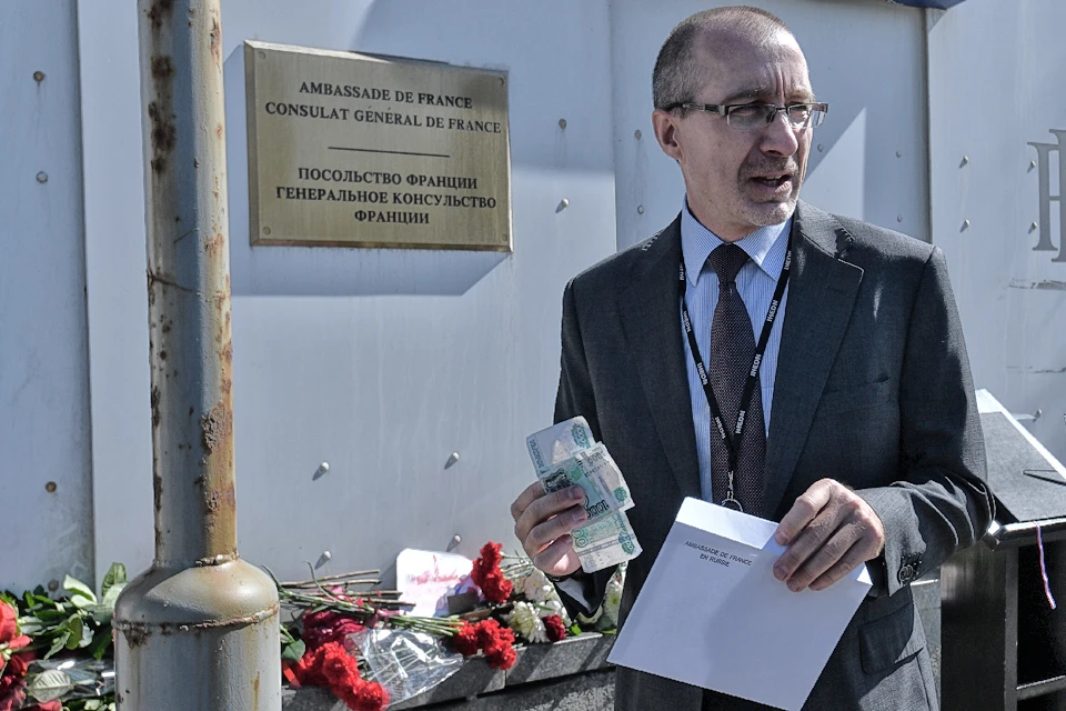 К стенам посольства Франции в Москве неравнодушные несут цветы, рисунки и... пожертвования на восстановление собора.