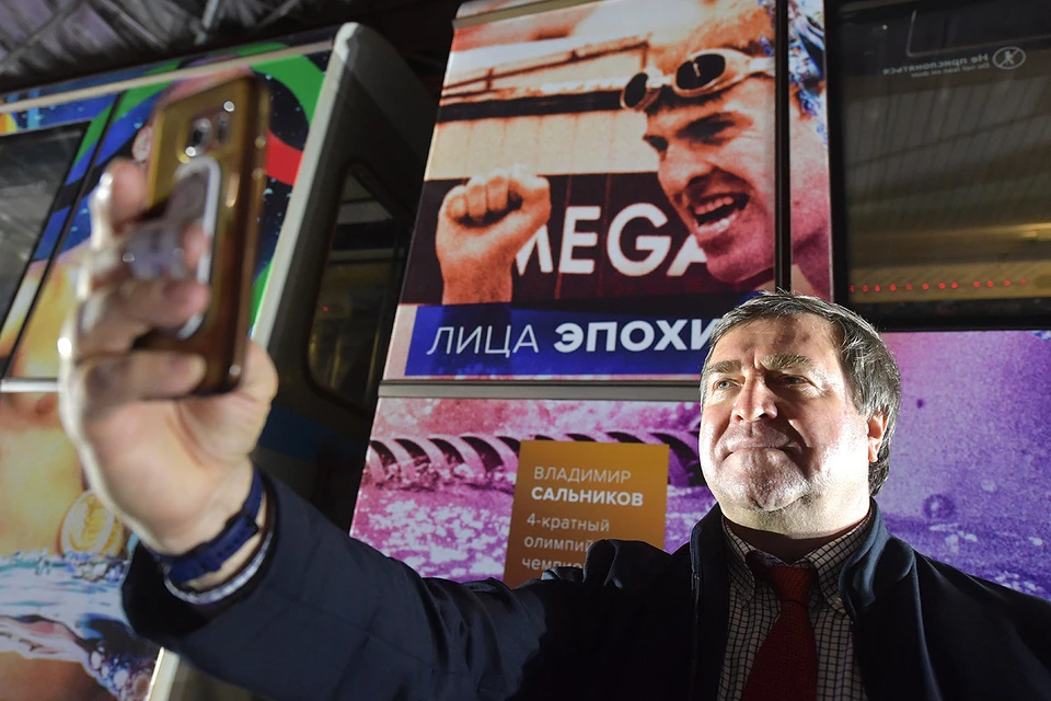 Четырехкратный олимпийский чемпион Владимир Сальников у своего фотопортрета на поезде.