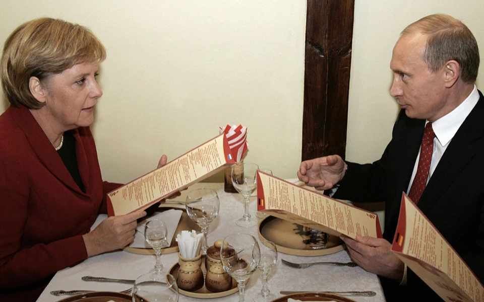 Владимир Путин угощает Ангелу Меркель медвежатиной в томском ресторане «Вечный зов», 2006 год.