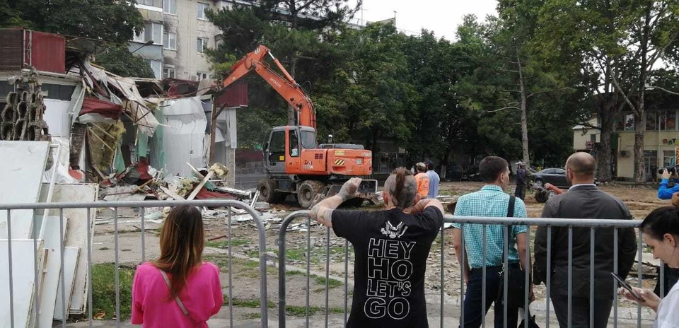 Строительная техника разбирает постройку.