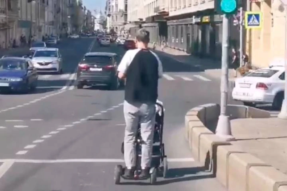 Современный отец на гироскутере с детской коляской проехал по проезжей части в центре Петербурга