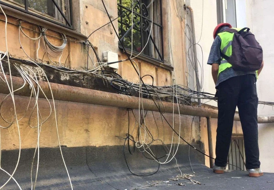 Рабочие приводят в порядок "скопище" проводов, которые портят внешний вид строений. Фото: пресс-служба администрации Симферополя