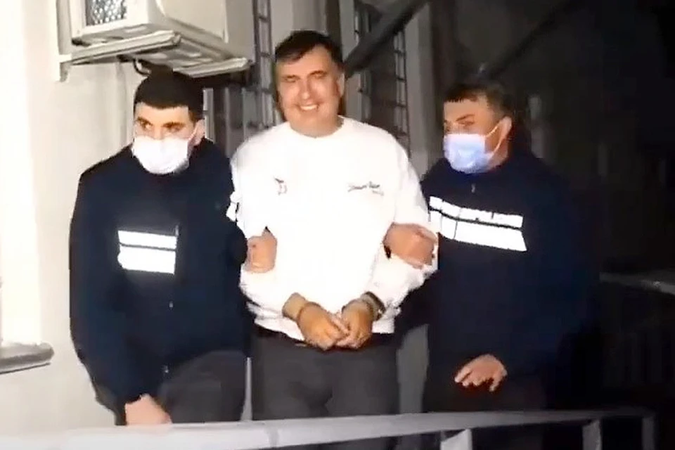 Михаил Саакашвили отправился за решетку с улыбкой на лице. Кадр из видеорепортажа грузинского ТВ о задержании экс-президента
