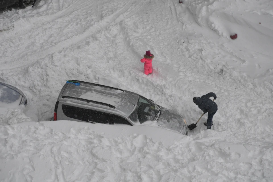 Автомобили буквально тонут под горами снега.