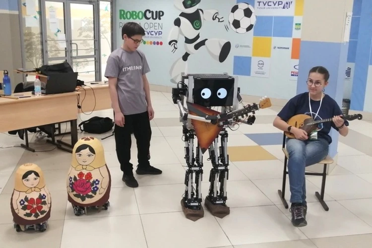 Школьники из Петербурга научили робота Железный Генри играть на балалайке под танцы матрешек