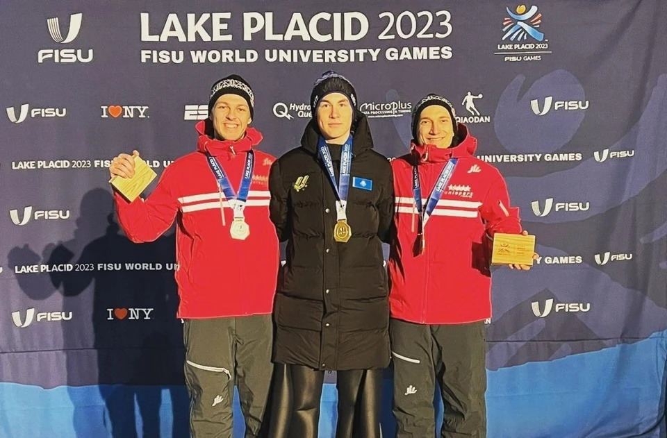 Казахстанский лыжник Данил Васильев (в центре) завоевал золотую медаль по прыжкам с трамплина на Универсиаде в Лейк-Плэсиде.