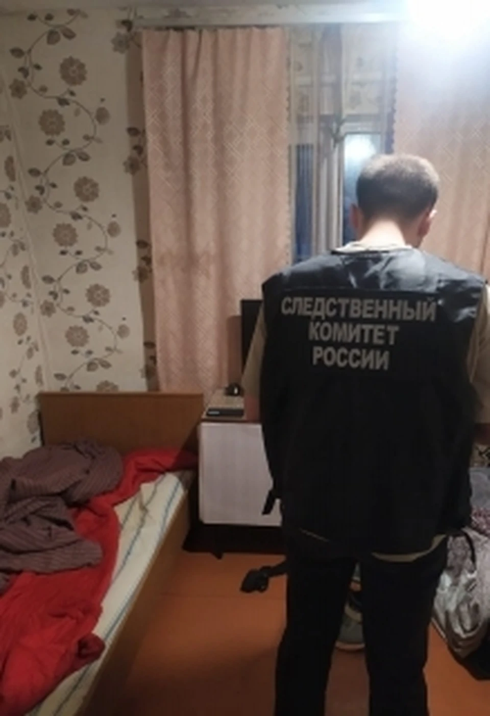 На месте преступления работает сотрудник Следственного комитета.