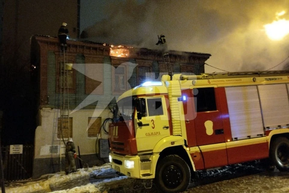 Пожарные тушат огонь, который охватил крышу нежилого дома в центре города