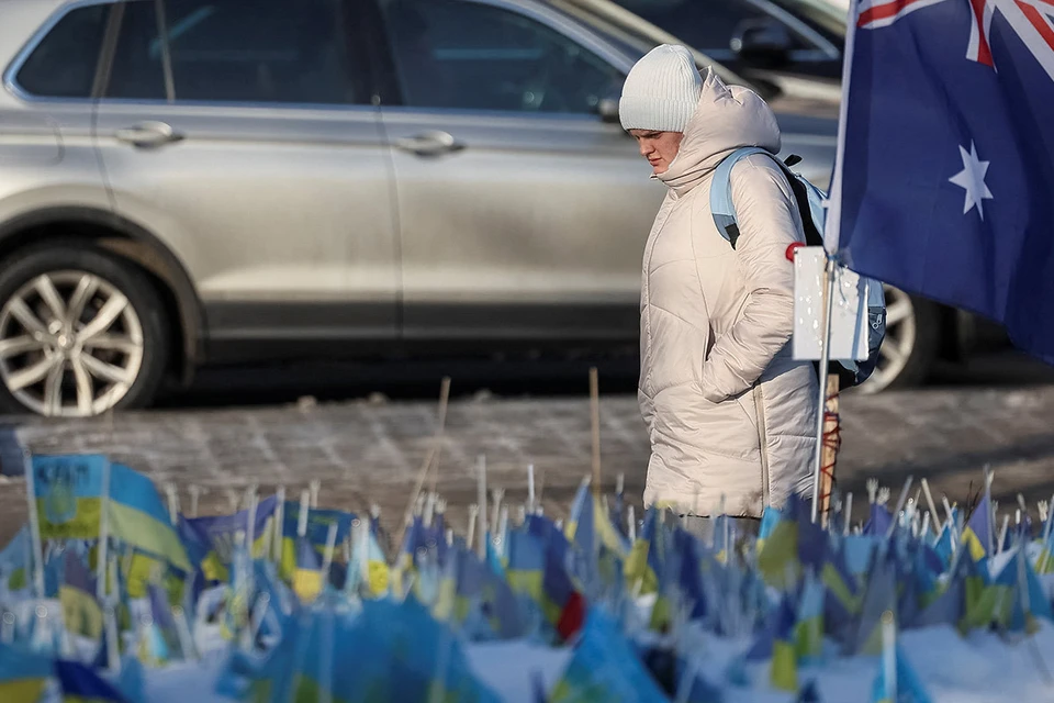 Жительница Киева проходит мимо мемориала в центре города.