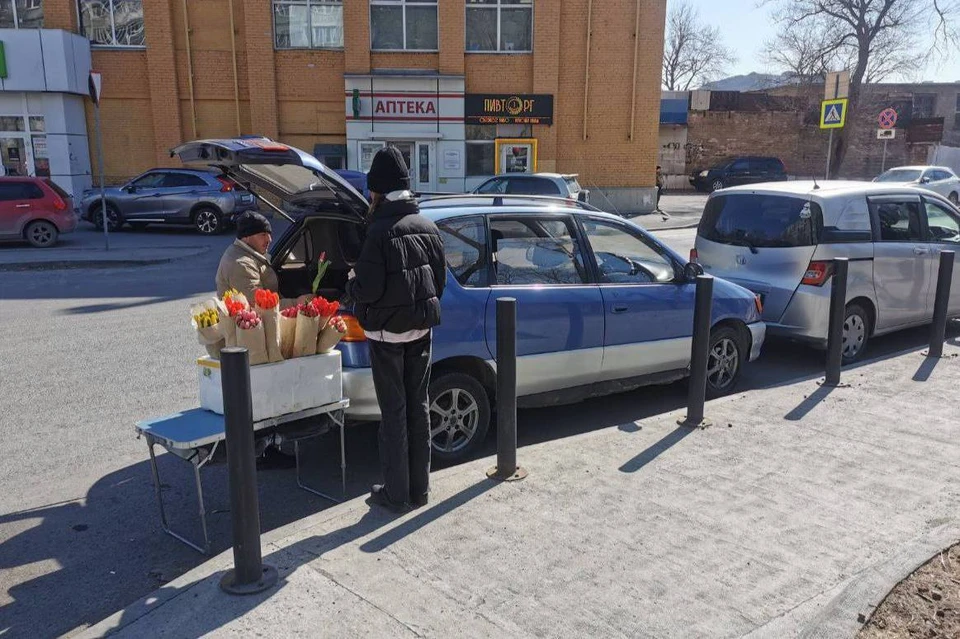 Припаркованные машины с тюльпанами мешают дорожному движению.