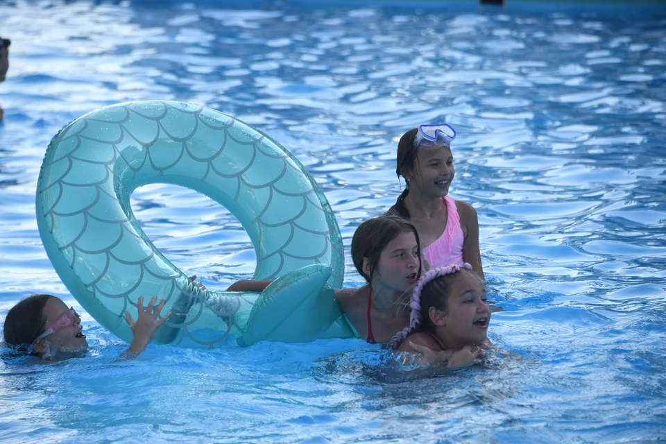 Отдыхающие плавают в Черном море.