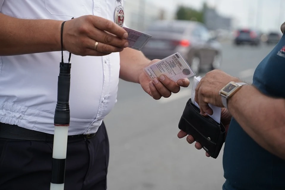 Сотрудник ДПС проверяет документы у водителя