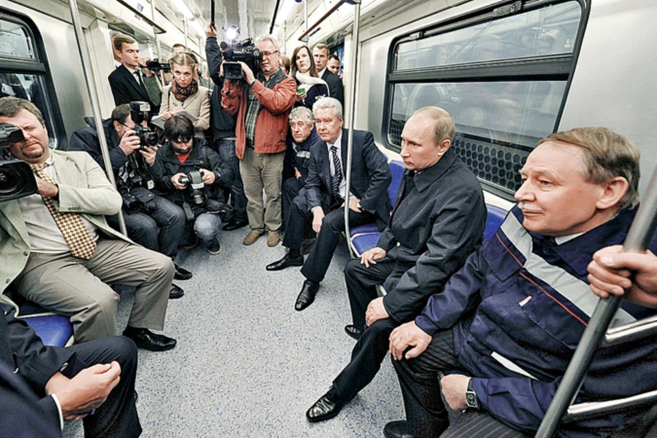 Владимир Путин, Сергей Собянин (третий справа), рабочие-метростроевцы и журналисты - первые пассажиры станции метро «Новокосино».