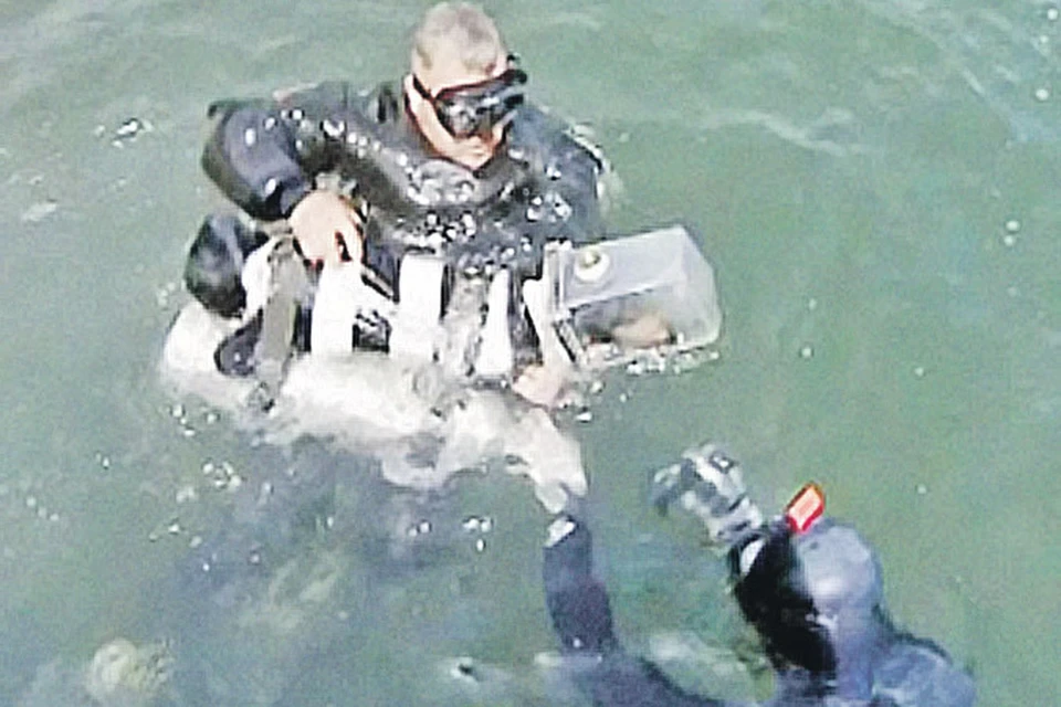 Сергей Горбунов сам сделал для пса акваланг. На фото он учит своего питомца плавать.