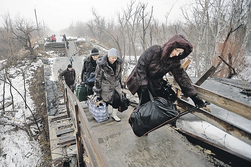 Этот мост между Украиной и Новороссией взорвали во время боев 2014-го.  Да так и оставили.  Люди туда и обратно карабкаются, как альпинисты.