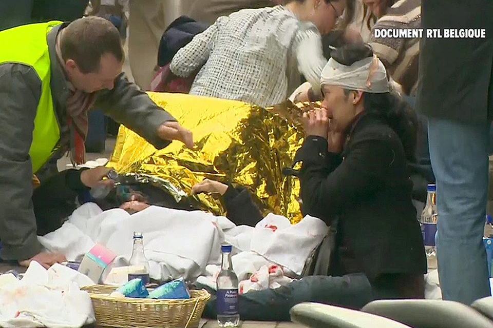 Медики оказывают помощь пострадавшему в брюссельских терактах.