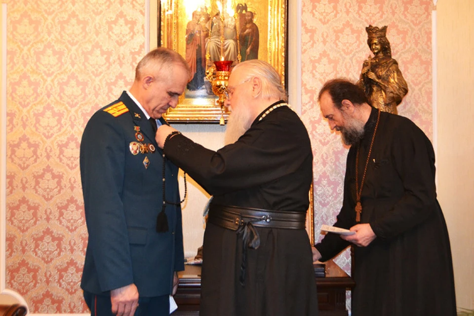Владыка Исидор вручает Роману Соколовскому медаль.