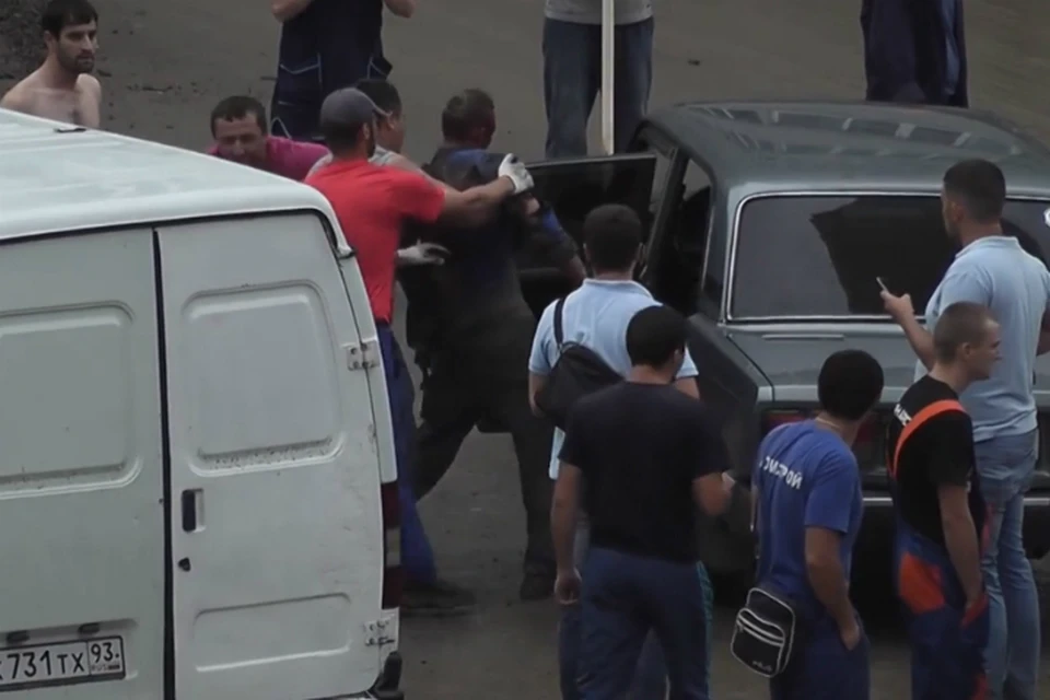 Мужчину, получившего ранения во время работ на электроподстанции, к машине под руки вели несколько человек. Фото: стоп-кадр с видео ВКонтакте, группа "Ростов-на-Дону | Главный"