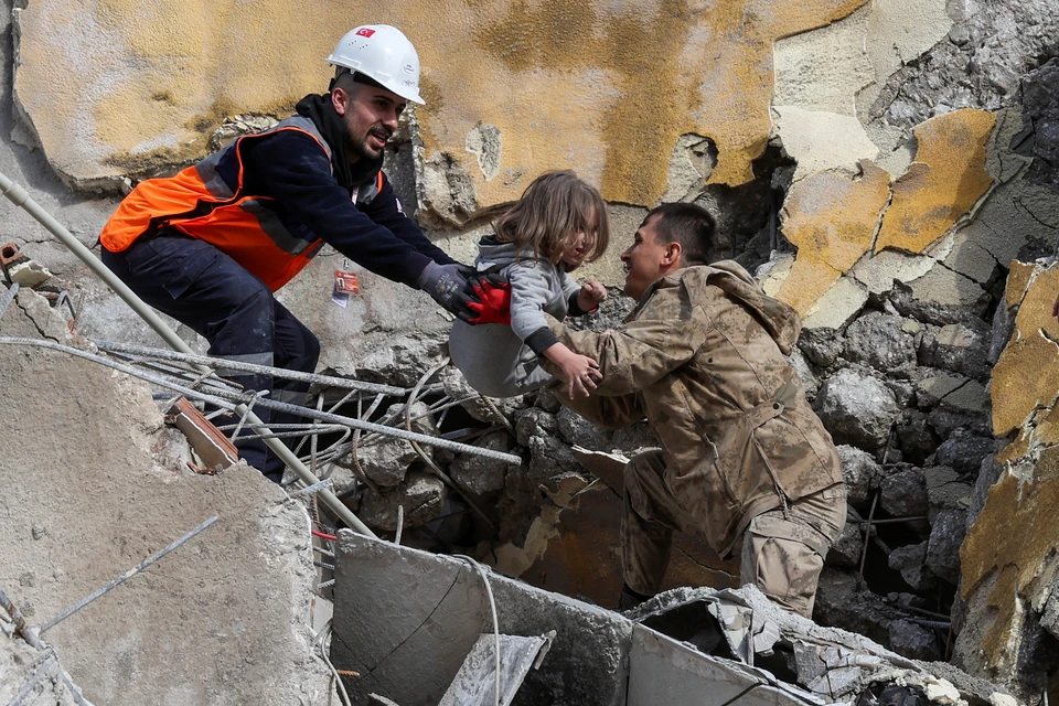 Турецкие спасатели передают друг другу пятилетнего ребенка, извлеченного из-под обломков рухнувшего здания в городе Хатай. Тем временем власти сообщают, что число жертв землетрясения превысило 3,5 тысячи человек. Фото: REUTERS