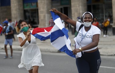 На митинги протестов кубинские власти ответили выходом на улицу «защитников революции» (как на фото) - и те и другие сражались за свои идеалы пританцовывая. Фото: Yander Zamora/Getty Images